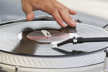 The dj uses vinyl records to mix electronic music and beat rap sound.