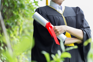 Women Student Graduate holding certificate in her hand and feeling so proud and happiness in Commencement day