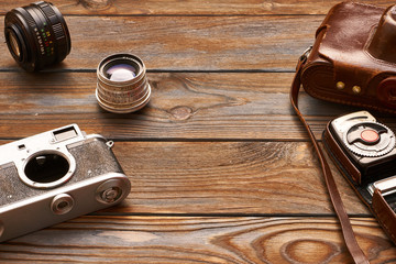 Vintage cameras and lenses on wooden background