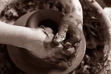 Potter shaping clay on the pottery wheel

