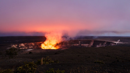 Fiery glow of the lava lake of Kilauea's active crater of Halemaumau at nightfall, view from the...