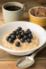 Blueberry topped Oatmeal and Coffee on Wooden Background