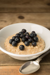 Breakfast Porridge, Blueberry Topped Oatmeal on Wooden Backgroun