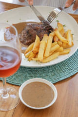 Beef steak served with black pepper sauce and french fries
