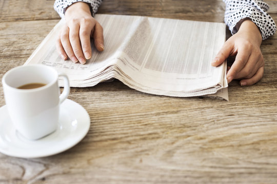 Reading newspaper on wooden table