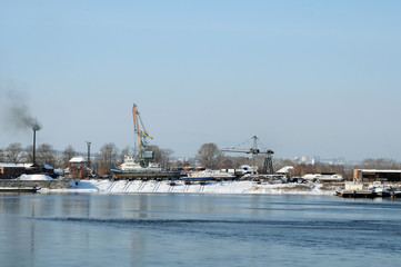 Winter view of the river port of the river. Pleasure boats are in dry dock on the shore.