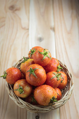 tomatoes in basket on wooden table
