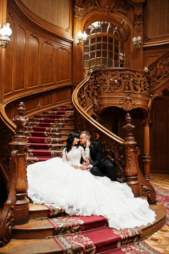 Charming wedding couple sitting on rich wooden stairs on great r