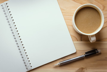 notebook checked with a pencil and a cup of coffee