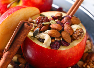 Red juicy apple with assorted nuts , raisins and cinnamon