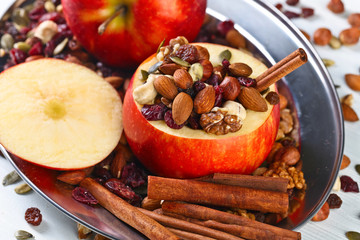 Red juicy apple with assorted nuts , raisins and cinnamon