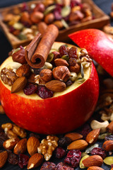 Red juicy apple with assorted nuts , raisins and cinnamon