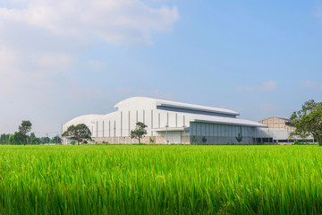 Factory in the middle of a green farmland on a cloudy day..