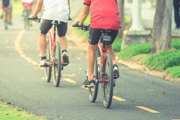 Naklejka premium Cyclists ride along bike path in park , vintage