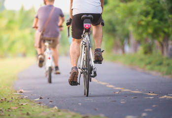 Cyclists ride along bike path in park