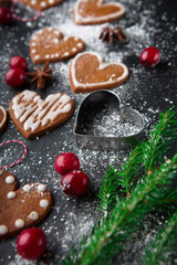 Christmas gingerbread cookies with festive decoration on black stone background, selective focus. Winter Holiday concept
