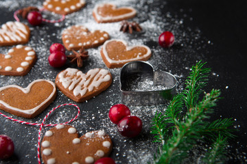 Christmas gingerbread cookies with festive decoration on black stone background, selective focus. Winter Holiday concept