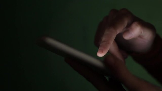 Panning footage of a person's hands using a tablet.