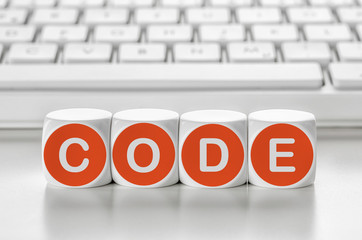 Buchstabenwürfel vor einer Tastatur - Code