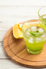 cocktail with tarragon, lemon and ice on a white background