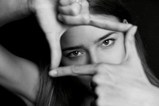 The girl with long hair holding his hands in front of my eyes for the frame. Black and white, Studio