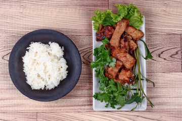 Grilled pork with mixed herb served sticky rice .