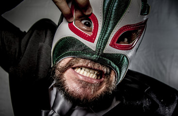 Angry businessman with mask of Mexican fighter, dressed in suit