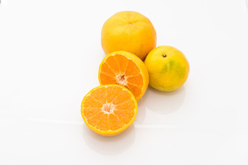 whole and half cut orange on white background