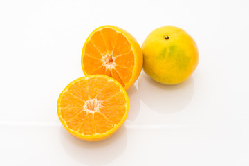 whole and half cut orange on white background