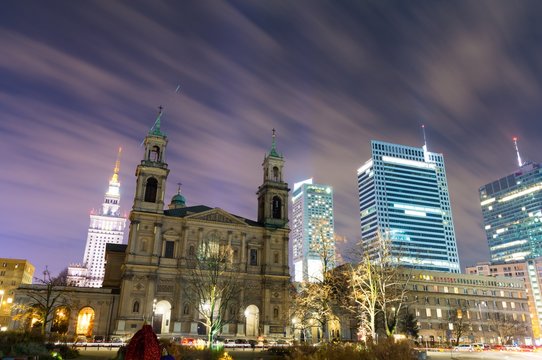 view on old church and modern skyscrapers in Warsaw at night, Poland