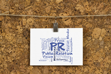 public relations word cloud on business card pinned up on cork board
