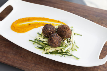 Meatballs with thinly sliced lentils and pumpkin dressing.