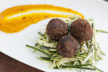 Meatballs with thinly sliced lentils and pumpkin dressing.