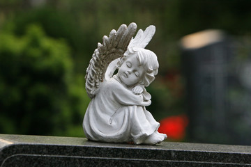 Little angel praying at graveyard