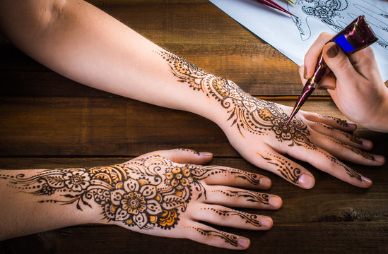 woman mehendi artist painting henna on the hand Stock Photo | Adobe Stock