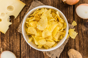 Portion of Potato Chips (Cheese and Onoion taste) on wooden back