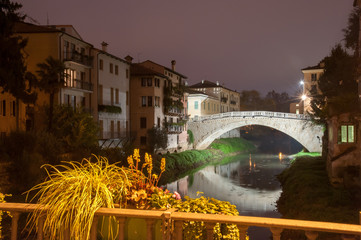 Night view of the old San Michele bridge seen from the flowered balcony of San Paolo bridge, Vicenza, Italy