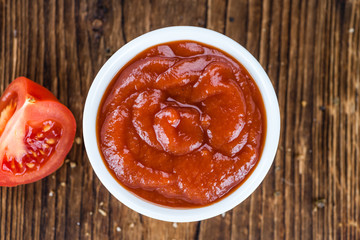 Tomato Ketchup (selective focus) on vintage wooden background