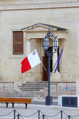 Flaga maltańska przed państwowymi budynkami w Vallettcie © andrzej_67