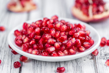 Pomegranate seeds on wooden background (selective focus)