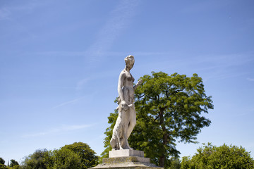 View of woman sculpture with trees and clear blue sky in the background at Jardin Des Tuileries in...