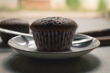 Cup cake on wood background with coffee cup.Vintage tone.Selective focus.Hard light tone.