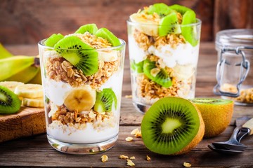 Healthy breakfast: yogurt parfait with granola, banana and kiwi - obrazy, fototapety, plakaty