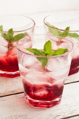 glasses with red cocktail with ice and mint