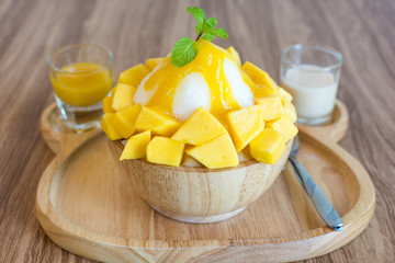 Bingsu ( Korea food) mango served with sweetened condensed milk on table