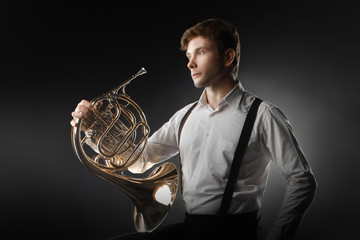 French horn player playing music instrument