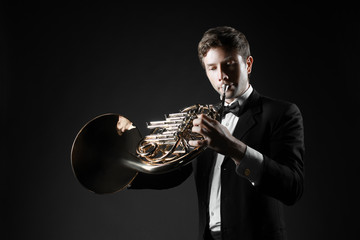French horn player playing music instrument