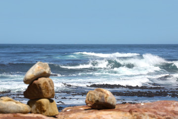 big waves at the ocean with unsharp stones on the waterfront in the foreground