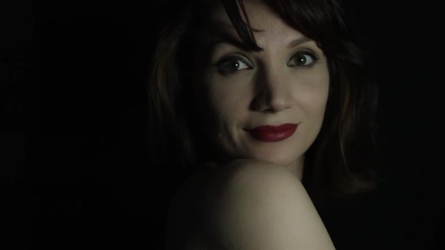 4k shoot of a woman in studio turning and looking at camera