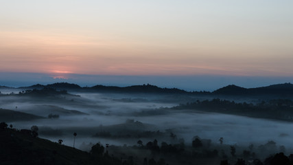 The sunrise with a fog in winter